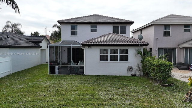 back of property featuring a lawn and a sunroom