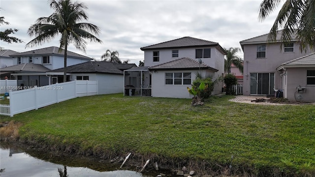 rear view of house featuring a lawn and a sunroom