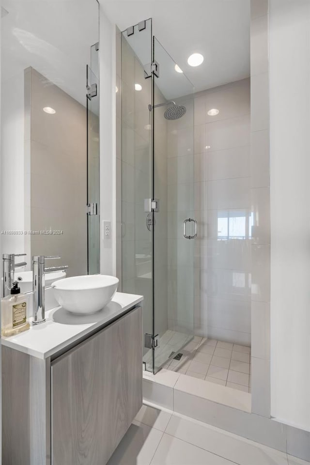 bathroom featuring tile patterned flooring, vanity, and a shower with shower door