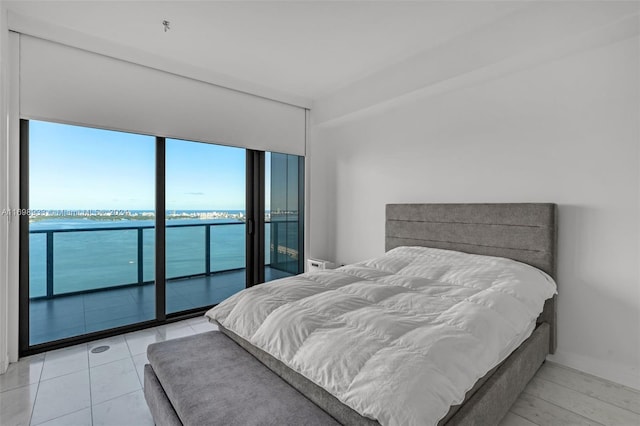 bedroom featuring access to outside and a water view