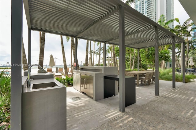 view of patio / terrace featuring a pergola, sink, and exterior kitchen