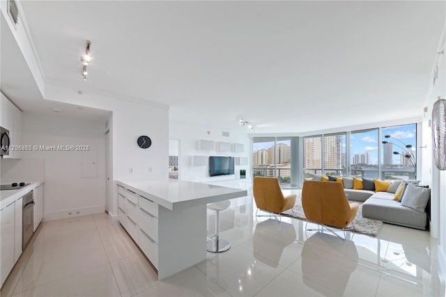 kitchen with kitchen peninsula, light tile patterned floors, stainless steel appliances, and white cabinetry