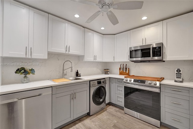 kitchen featuring sink, ceiling fan, light hardwood / wood-style floors, washer / dryer, and stainless steel appliances