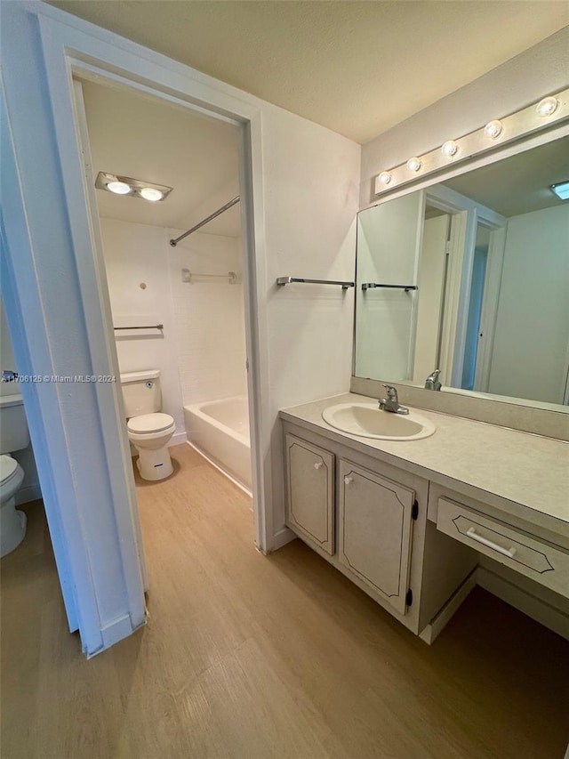 bathroom with hardwood / wood-style flooring, vanity, and toilet