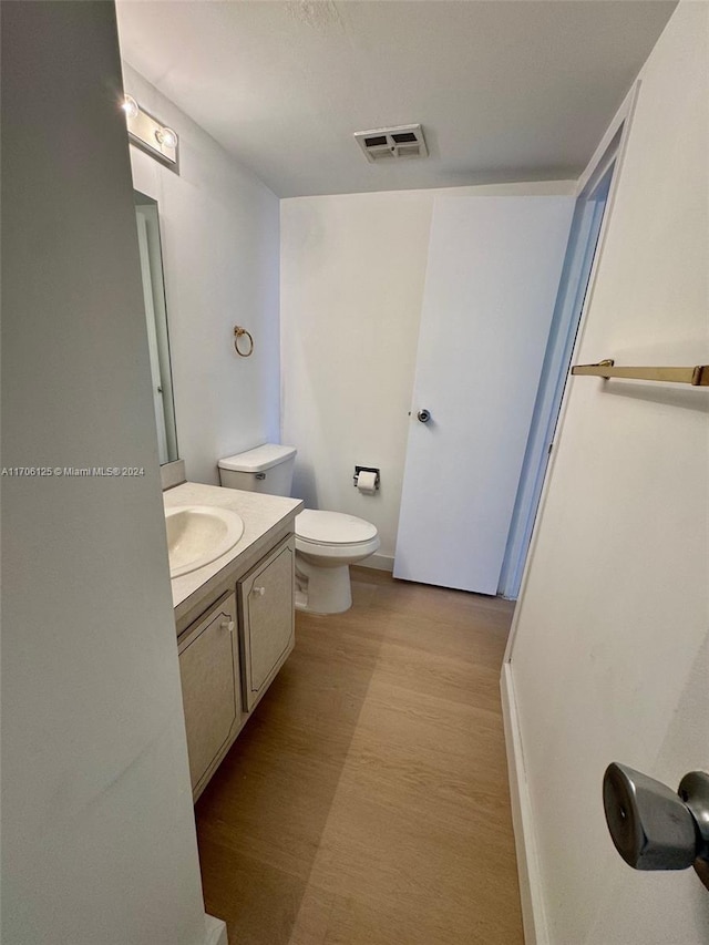 bathroom featuring hardwood / wood-style floors, vanity, and toilet