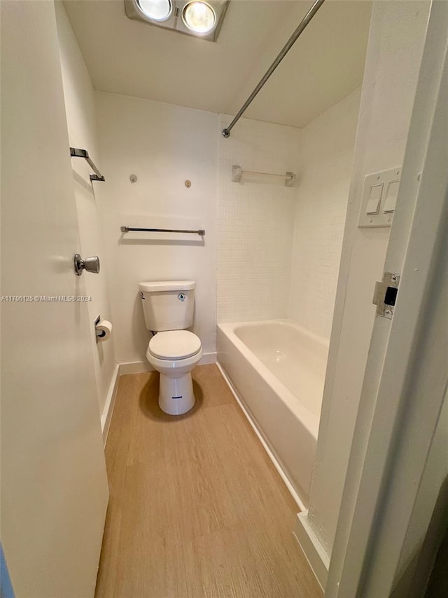 bathroom with toilet, wood-type flooring, and tub / shower combination