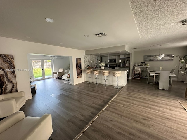 living room with french doors, dark hardwood / wood-style flooring, and a textured ceiling