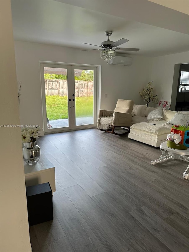 unfurnished living room featuring hardwood / wood-style floors, french doors, a wall unit AC, and ceiling fan