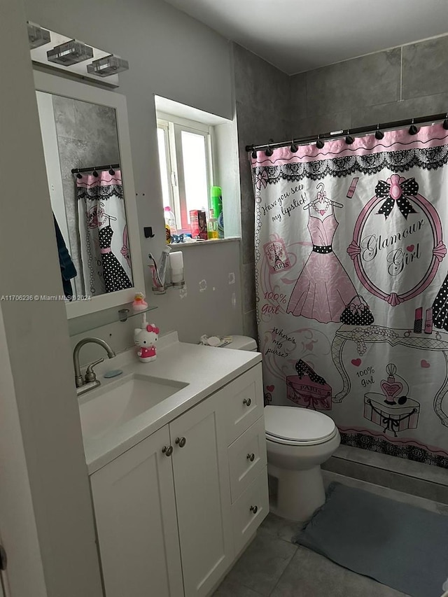 bathroom featuring toilet, a shower with curtain, vanity, and tile patterned floors