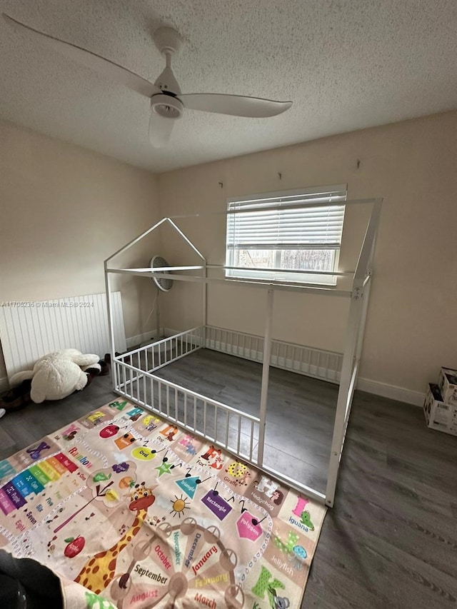 unfurnished bedroom featuring a textured ceiling, dark hardwood / wood-style flooring, and ceiling fan