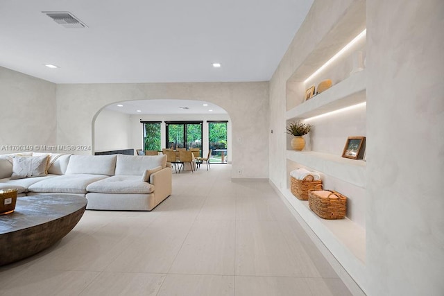 living room featuring light tile patterned floors and built in features