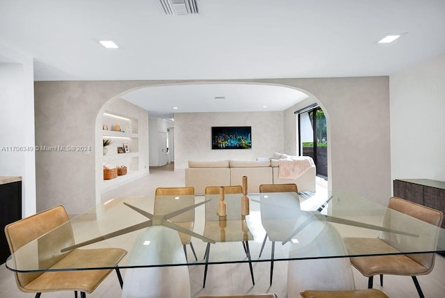 tiled dining room featuring built in shelves