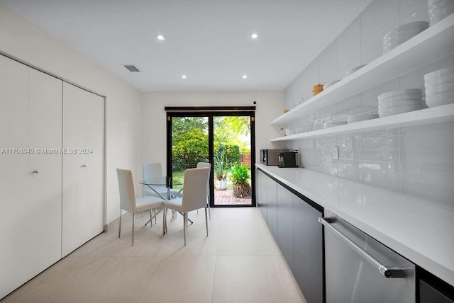 kitchen with white cabinets, light tile patterned floors, tasteful backsplash, and stainless steel dishwasher