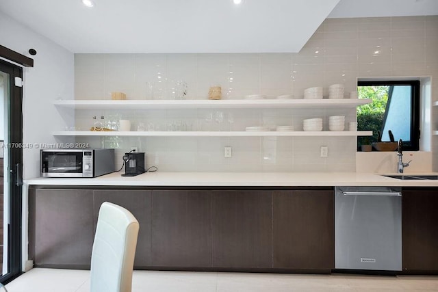 kitchen featuring sink, decorative backsplash, dark brown cabinets, light tile patterned floors, and appliances with stainless steel finishes