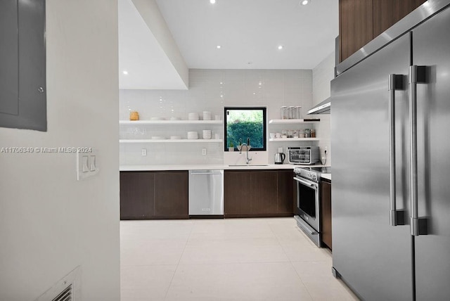 kitchen with light tile patterned floors, sink, appliances with stainless steel finishes, and tasteful backsplash