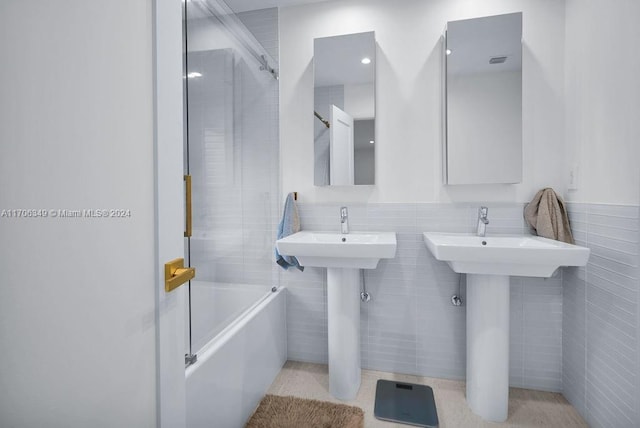 bathroom featuring tile walls and tiled shower / bath