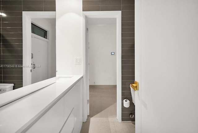 bathroom featuring vanity and tile walls