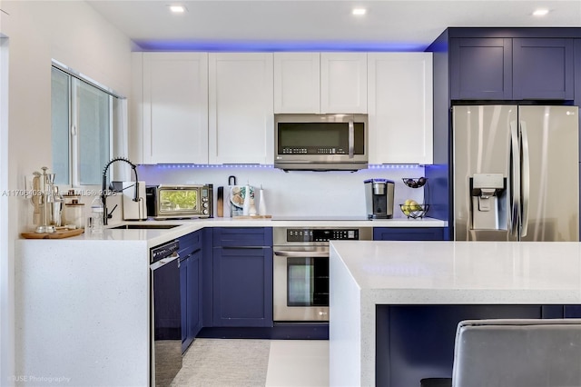 kitchen with white cabinetry, sink, stainless steel appliances, and blue cabinets