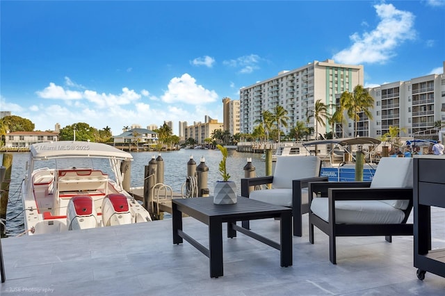 view of patio with a water view and a dock