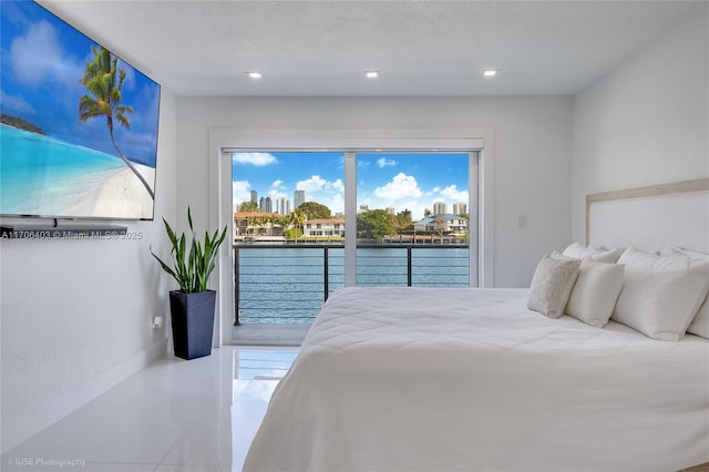 bedroom featuring a water view, access to exterior, and a textured ceiling