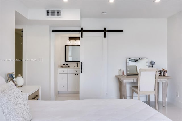 bedroom featuring a barn door and sink