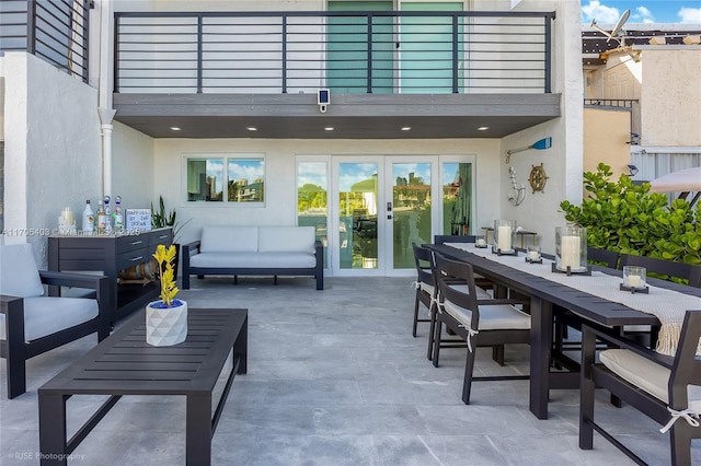 view of patio with a balcony, an outdoor hangout area, and french doors