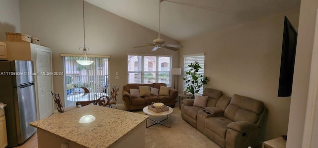 tiled living room with ceiling fan and high vaulted ceiling