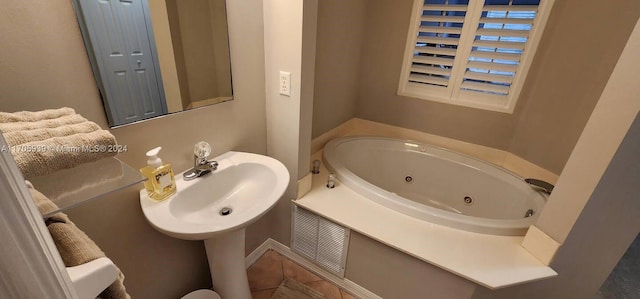 bathroom featuring a tub to relax in, tile patterned floors, and sink