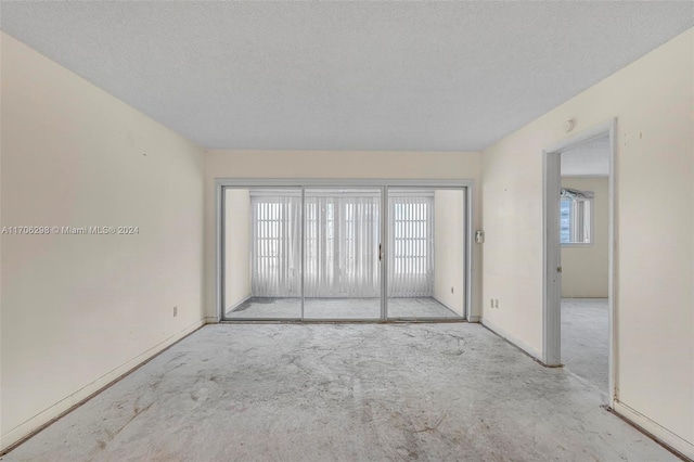 unfurnished room with a textured ceiling