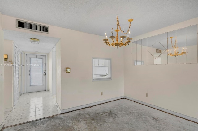 unfurnished dining area with a textured ceiling and a notable chandelier