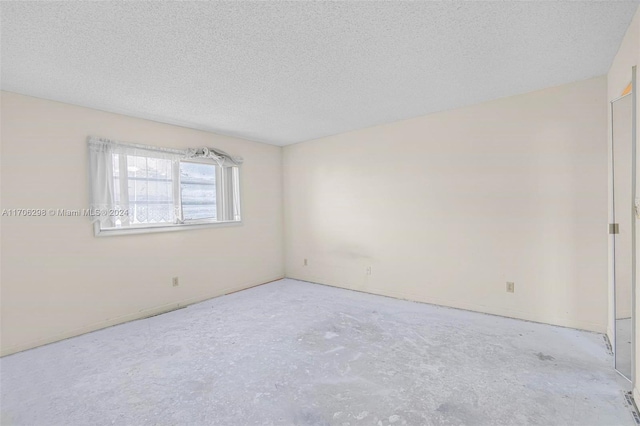 unfurnished room with a textured ceiling