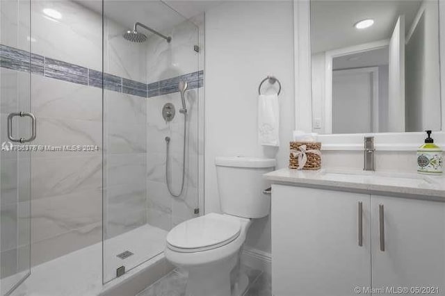 bathroom featuring toilet, an enclosed shower, and vanity