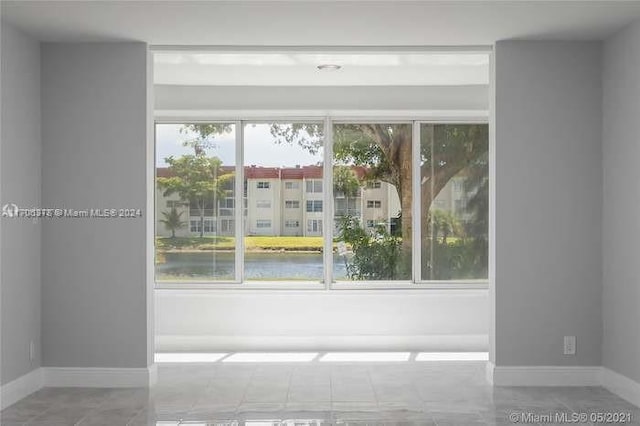 interior space featuring a water view and tile patterned floors