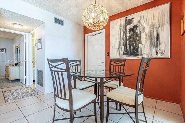 dining room featuring a notable chandelier, a textured ceiling, and light tile patterned floors