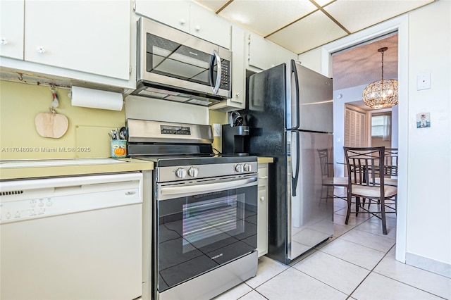 kitchen with light tile patterned flooring, white cabinetry, hanging light fixtures, a notable chandelier, and stainless steel appliances