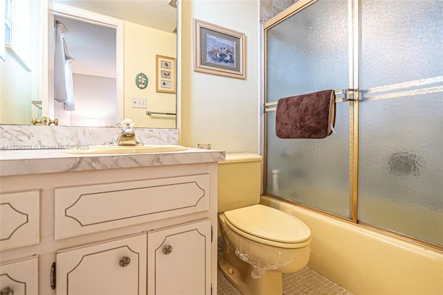 full bathroom with vanity, bath / shower combo with glass door, tile patterned floors, and toilet