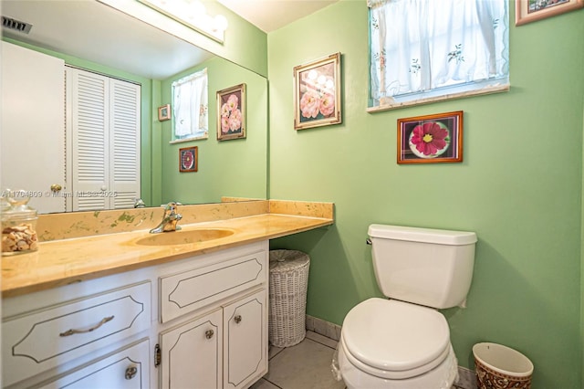 bathroom featuring vanity, tile patterned floors, and toilet