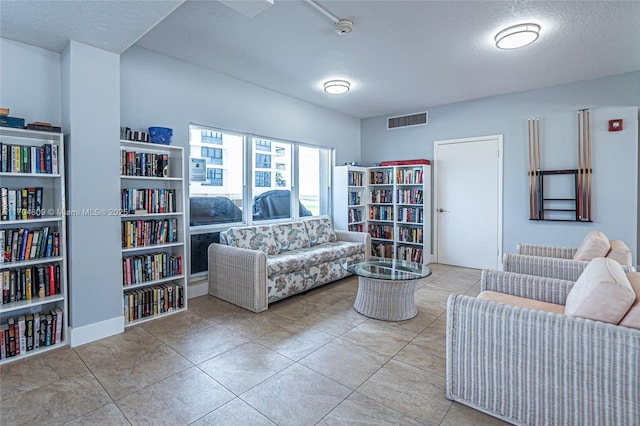 tiled living room featuring a textured ceiling