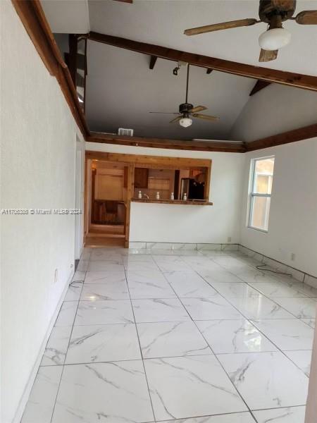 unfurnished living room with beamed ceiling and high vaulted ceiling