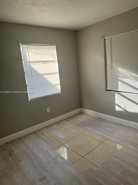 spare room with light hardwood / wood-style floors and a textured ceiling