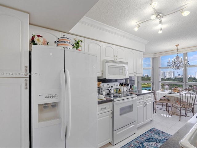 kitchen with an inviting chandelier, light tile patterned floors, white cabinetry, white appliances, and a textured ceiling