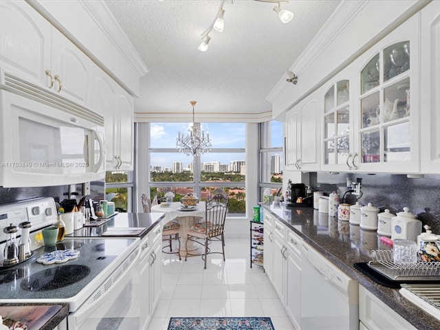 kitchen with white appliances, white cabinets, a textured ceiling, a chandelier, and light tile patterned floors