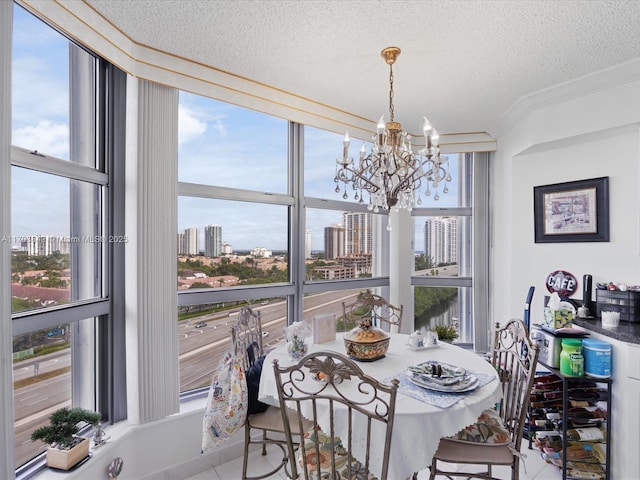 dining room featuring a textured ceiling, an inviting chandelier, light tile patterned floors, and ornamental molding