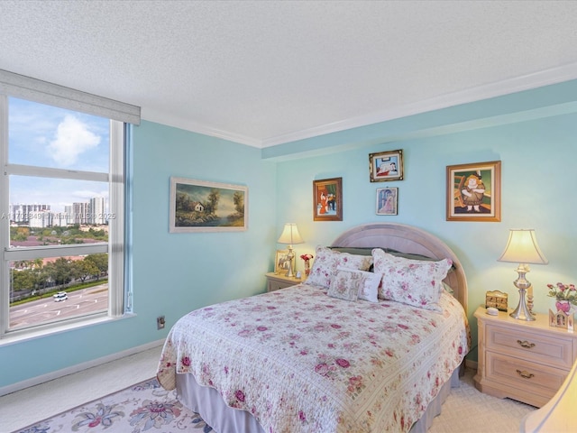 carpeted bedroom featuring ornamental molding and a textured ceiling