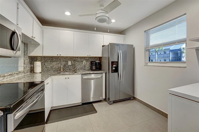 kitchen with decorative backsplash, stainless steel appliances, ceiling fan, sink, and white cabinets