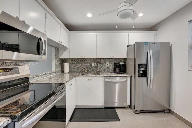 kitchen with decorative backsplash, ceiling fan, white cabinets, and stainless steel appliances