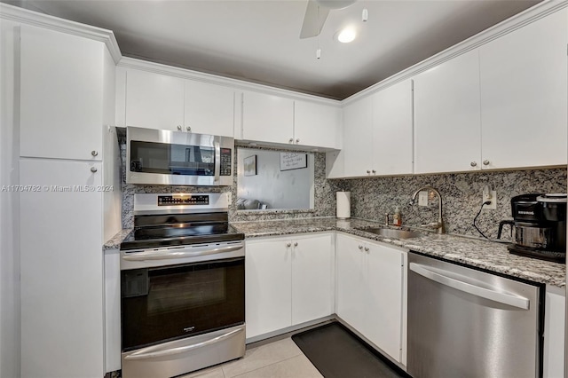 kitchen with light tile patterned floors, white cabinetry, sink, and appliances with stainless steel finishes