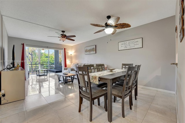 tiled dining room featuring ceiling fan and a textured ceiling