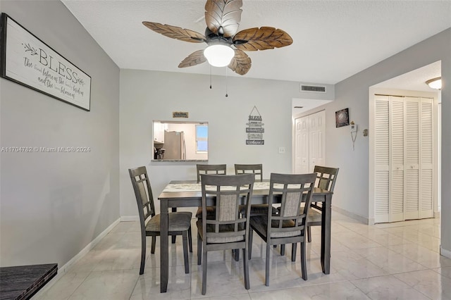 dining area with a textured ceiling and ceiling fan