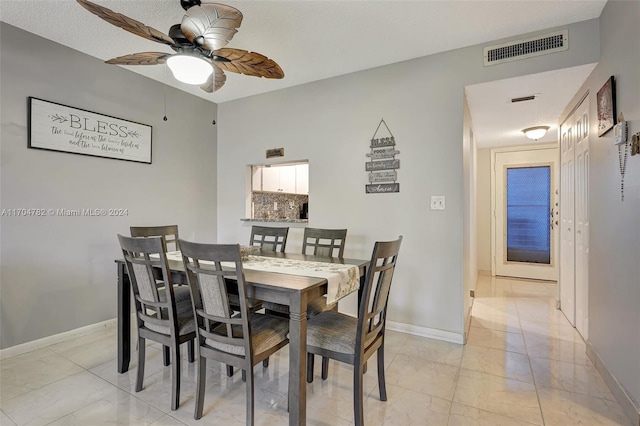 dining room with ceiling fan and a textured ceiling